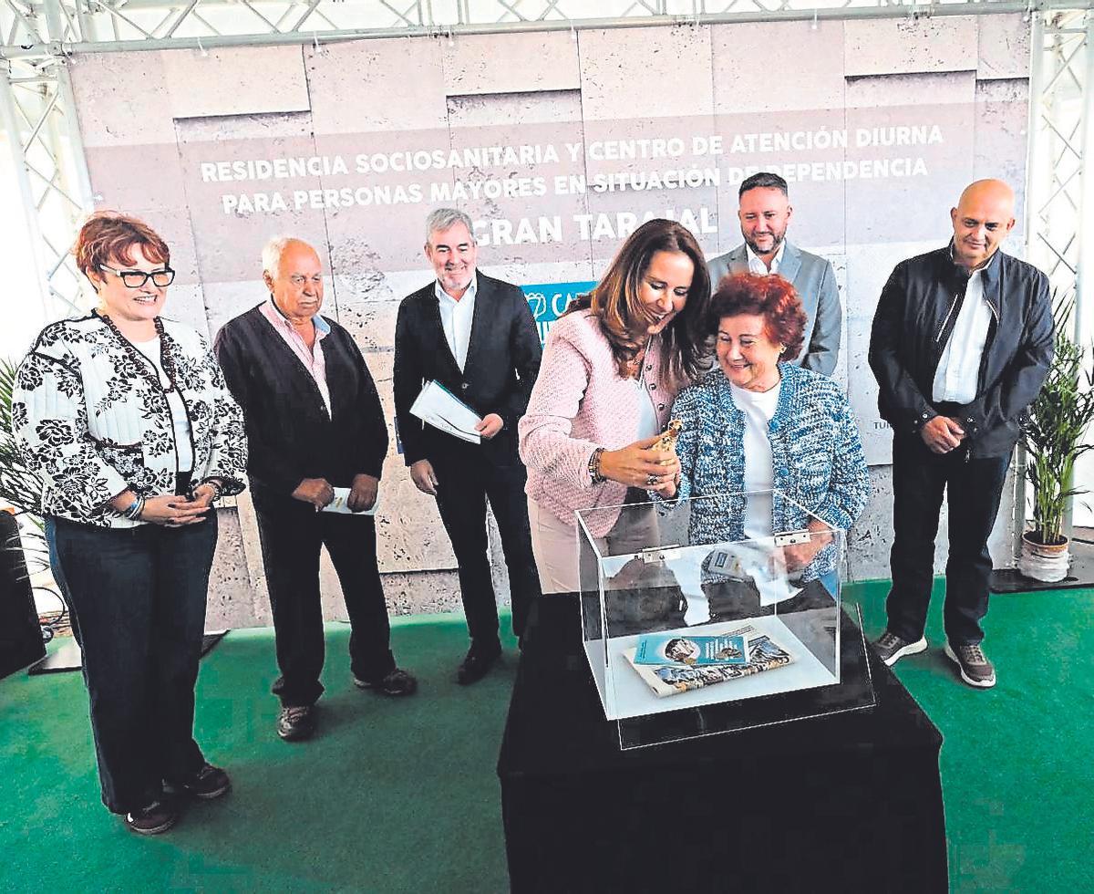 Lola García y la vecina Dorita Martín introducen una imagen de la Virgen de La Peña en la urna.