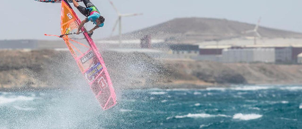 Un participante en las competiciones de windsurf de Pozo Izquierdo con los aerogeneradores de la costa de Santa Lucía al fondo.