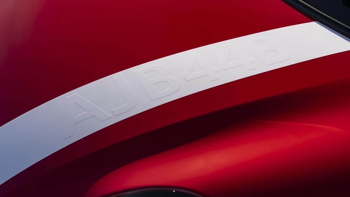 La franja blanca que cruza el capó evoca los colores clásicos del automovilismo de los años sesenta.