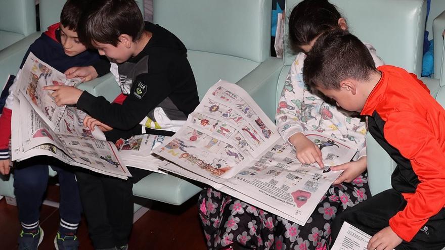 Escolares revisando os seus xornais