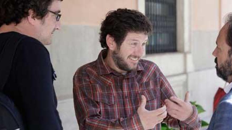 El líder de Poemos en Baleares, Alberto Jarabo, habla con dos diputados de Més, ayer a las puertas del Parlament.