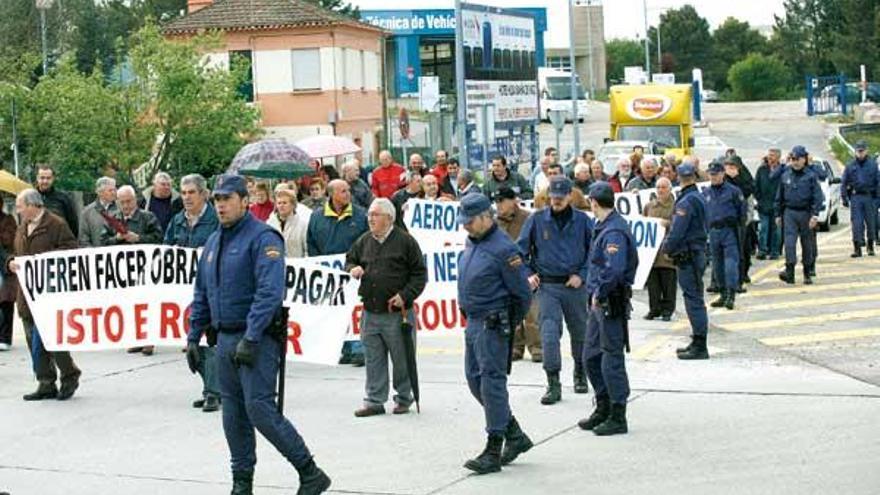 Los manifestantes, rodeados por policías, en la rotonda de Peinador.