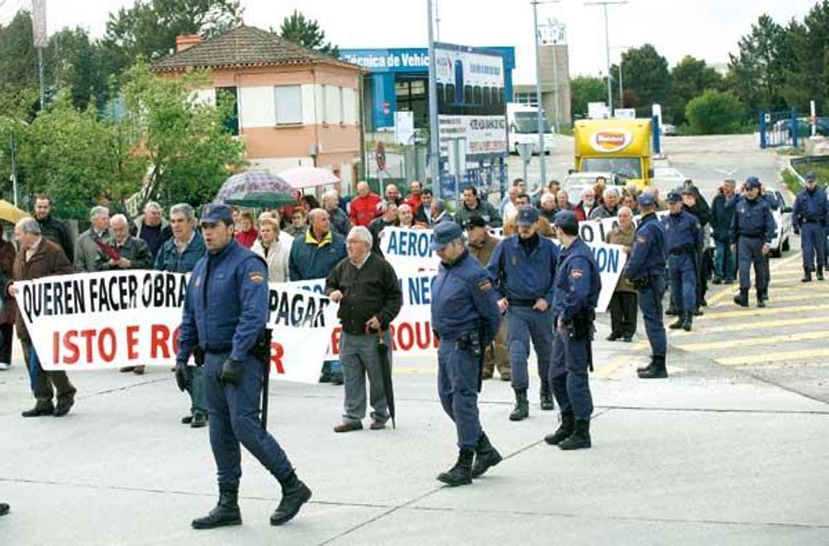 Los manifestantes, rodeados por policías, en la rotonda de Peinador.