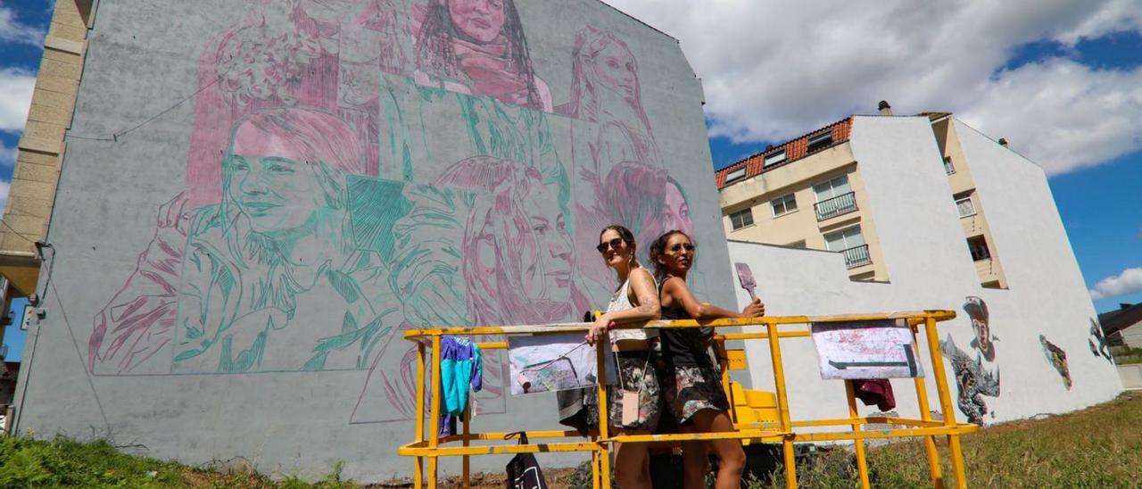 Nati y Lina, subidasa la grúa
 desde donde pintan un mural 
en Salceda.   | // ANXO GUTIÉRREZ