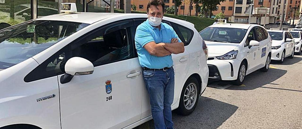 Gabino Pérez, junto a su taxi, en la parada provisional del HUCA.