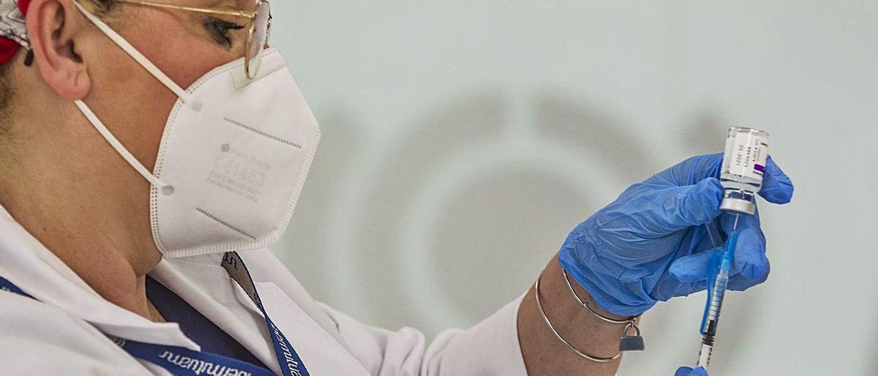 Una enfermera extrae una dosis de AstraZeneca de un vial. | ALEX DOMÍNGUEZ