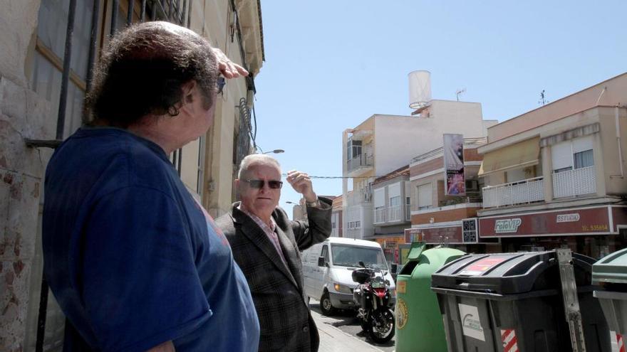 El presidente vecinal,  Eduardo Martínez (1d) , contempla una de las antenas de la calle Submarino.