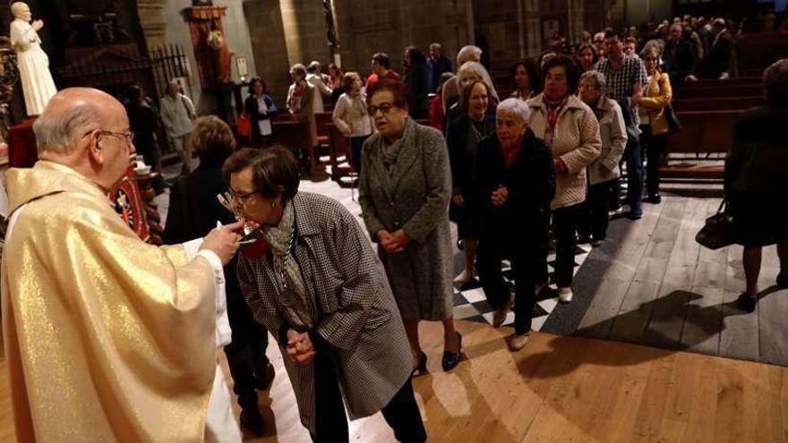 Fieles venerando ayer, en San Isidoro el Real, la reliquia de San Juan Pablo II, al final de la eucaristía.