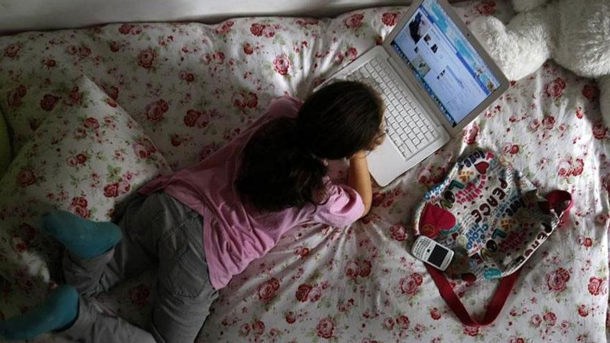 Una niña de 12 años navega en redes sociales desde la habitación de su casa. /