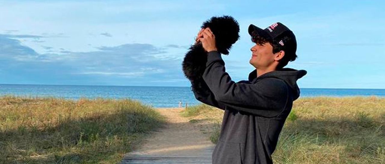 Javi Mier, con el caniche “Leo” en la playa de Rodiles.