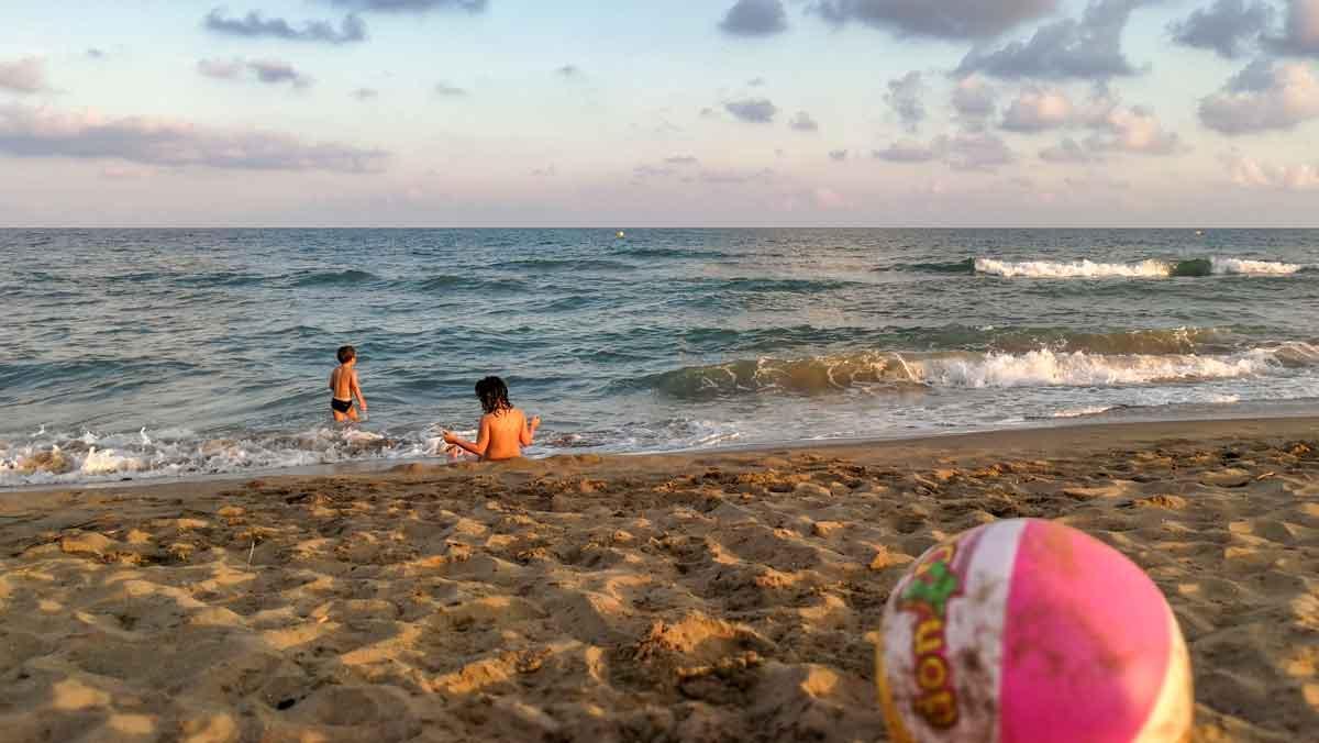 Dos nens juguen a la platja de El Prat de Llobregat.