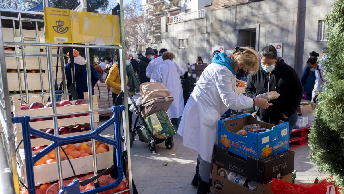 Una voluntaria entrega alimentos a personas vulnerables.