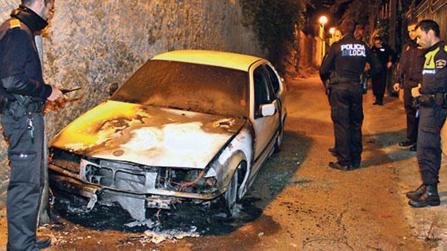 Varios policías, junto al vehículo que los ladrones robaron y al que pegaron fuego.