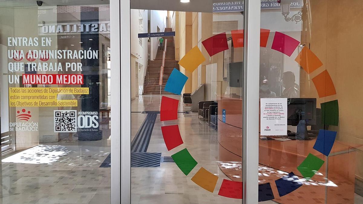 Puerta de acceso a uno de los edificios de la Diputación de Badajoz con el logotipo de los ODS.