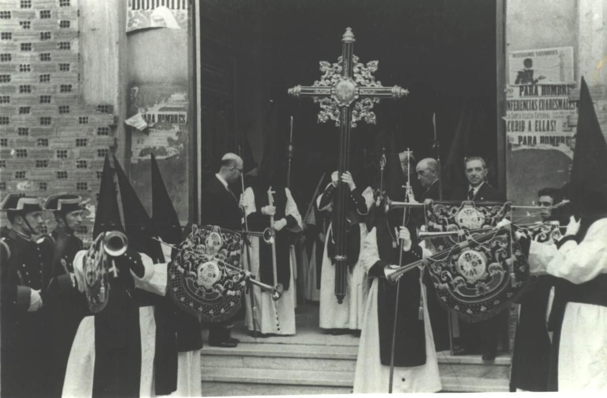 Varios hermanos nazarenos de la Soledad de Badajoz tocan la bocina para anunciar el inicio de la procesión que partía de la ermita nueva, aun en construcción.