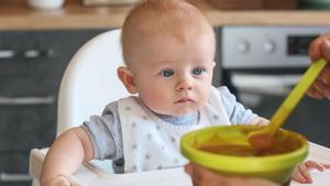 Una persona se dispone a dar de comer a un bebé