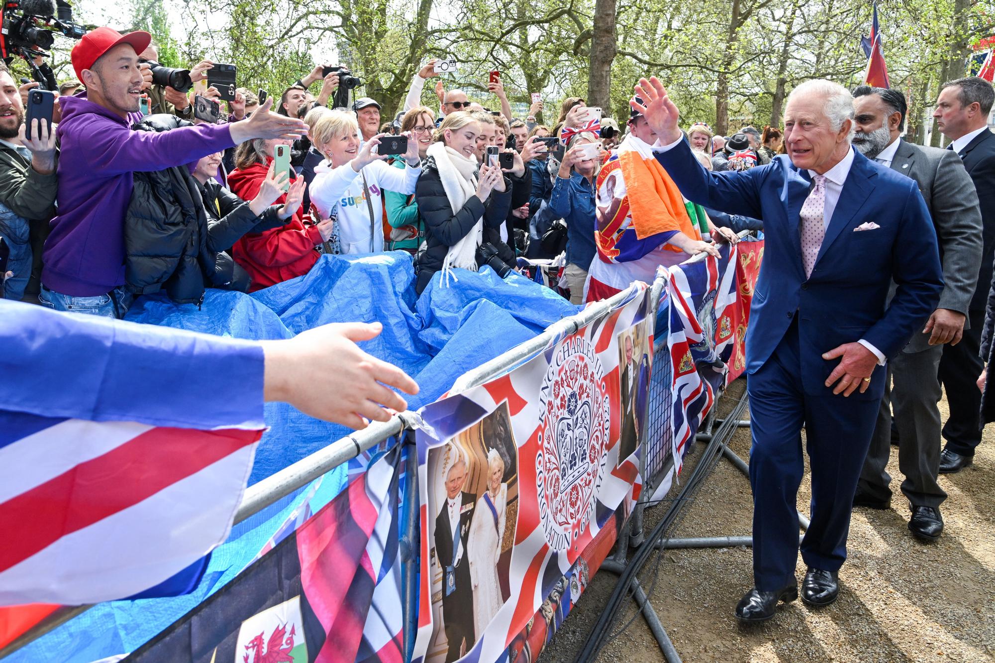 El rey Carlos saluda a la multitud congregada en el Mall, frente a Buckingham, este viernes.