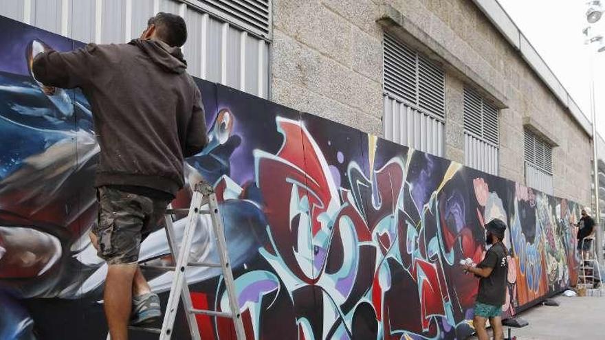 Distintos artistas pintaron graffitis en el mural de O Marisquiño durante la jornada de ayer. // Alba Villar