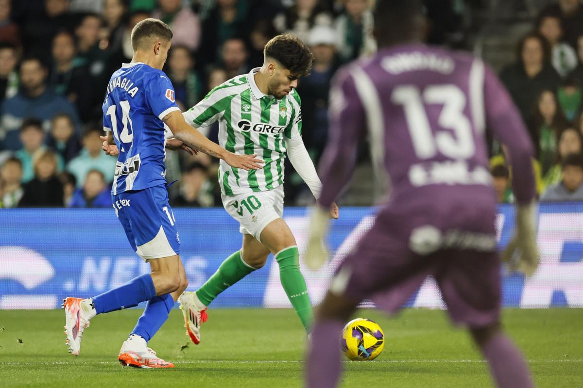 SEVILLA, 18/01/2025.- El delantero del Betis Ez Abde (c) juega un balón ante Nahuel Tenaglia, del Alavés, durante el partido de LaLiga de fútbol que Real Betis y Deportivo Alavés disputan este sábado en el estadio Benito Villamarín, en Sevilla. EFE/José Manuel Vidal