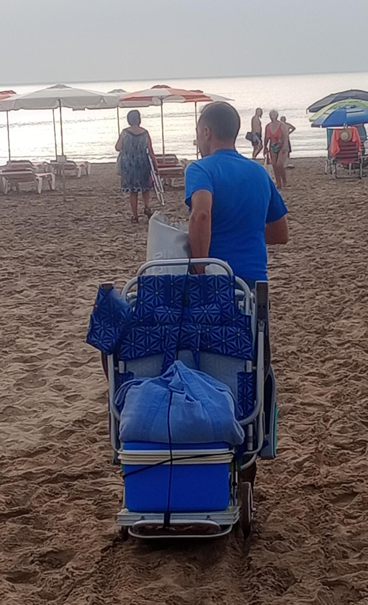 José, vecino de Algemesí, arrastra sus bártulos sobre la arena.
