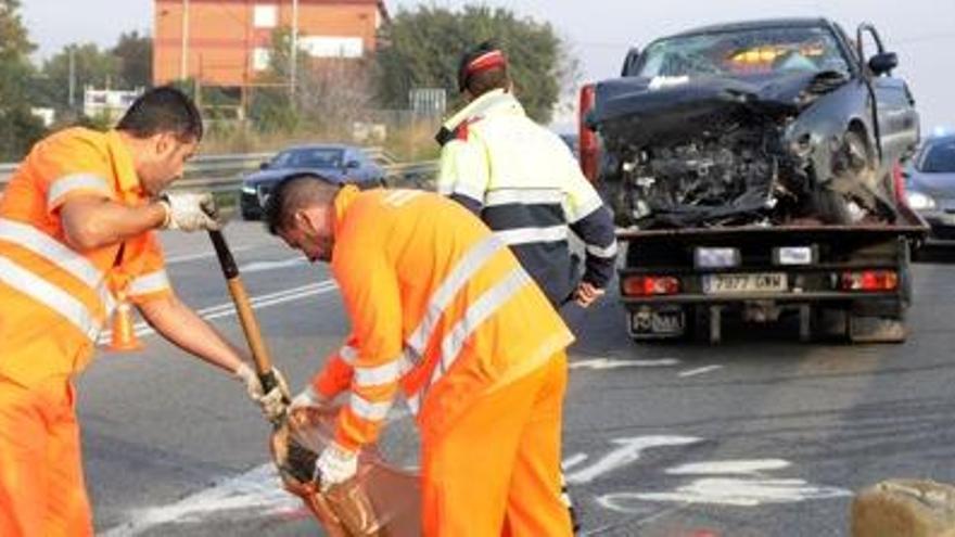 Operaris de Carreteres, darrere de la grua amb un dels cotxes sinistrats