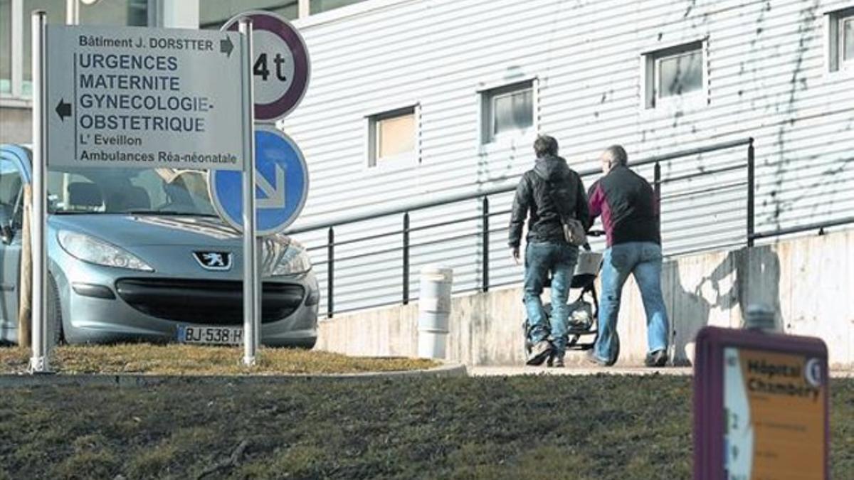 Dos personas se dirigen con un cochecito de bebé a la puerta de entrada del hospital de Chambéry, en los Alpes franceses.