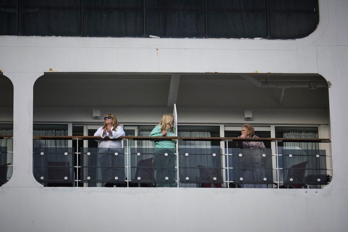 Bordeaux (France), 13/05/2026.- Passengers stand on a balcony aboard the Ambassador Cruise Line ship 'Ambition' docked on the Garonne river waterfront in Bordeaux, Nouvelle-Aquitaine region, southwestern France, 13 May 2026. Approximately 1,700 passengers and crew members remain confined to the vessel following a suspected norovirus outbreak, the most common cause of acute gastroenteritis. French authorities announced that the ban on disembarkation will be lifted for asymptomatic individuals currently aboard the cruise ship. The decision follows a health assessment that allows the cruise line to determine the ship's remaining itinerary while authorities maintain close monitoring of the evolving situation. (Francia, Burdeos) EFE/EPA/GUILLAUME PINON