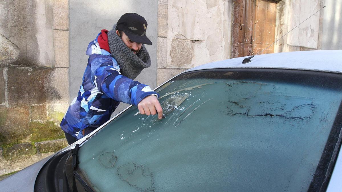 Foto de archivo de un ciudadano sacando el hielo del parabrisas del coche en Ourense.