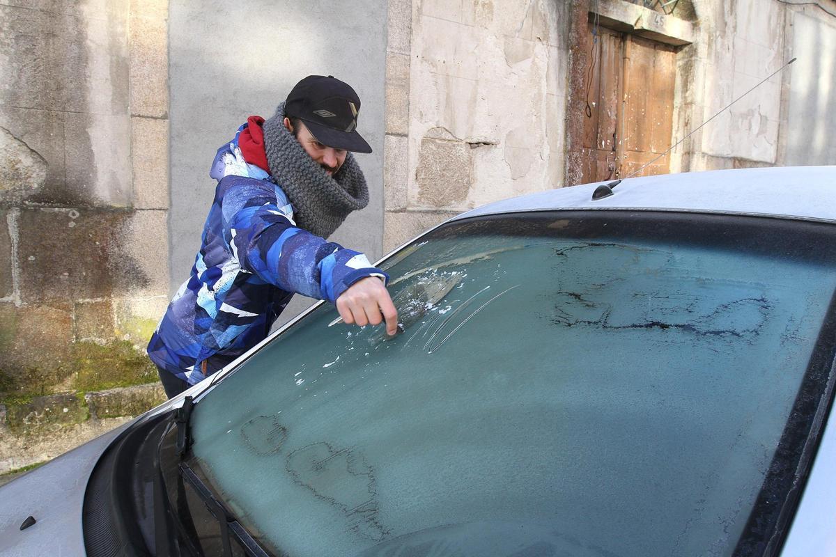 Foto de archivo de un ciudadano sacando el hielo del parabrisas del coche en Ourense.