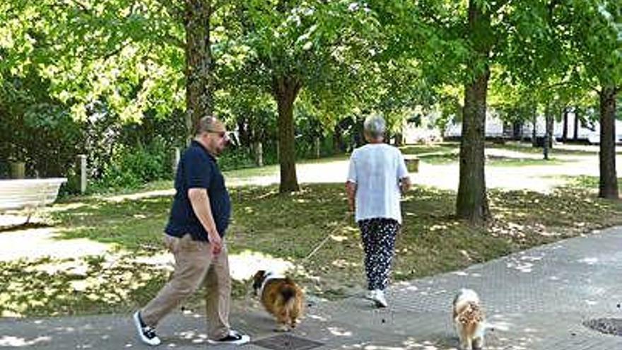 Vecina con perros y reguero blancuzco de una tubería en el río Mendo.