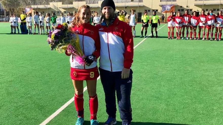 María López recibe un ramo de flores como reconocimiento a sus 150 internacionalidades de manos del seleccionador nacional, Adrian Lock.