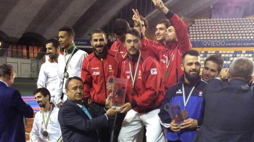 El presidente de la Federación Asturiana, Rodríguez Cabañas, entrega el trofeo de kumite por equipos a la selección española.