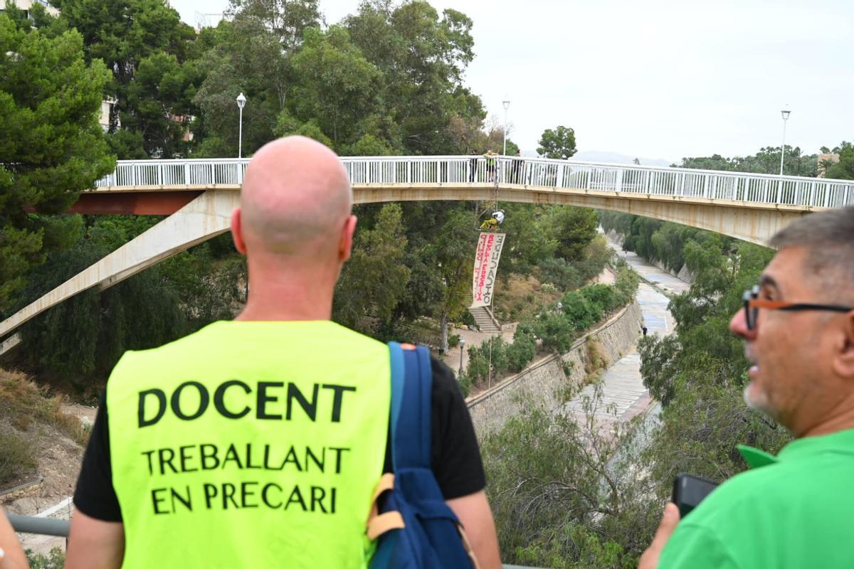 La huelga educativa escala en Elche: un profesor se cuelga de un puente con una pancarta