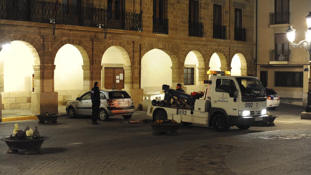 La grúa municipal llevándose un vehículo de la Plaza Mayor estacionado indebidamente un fin de semana.