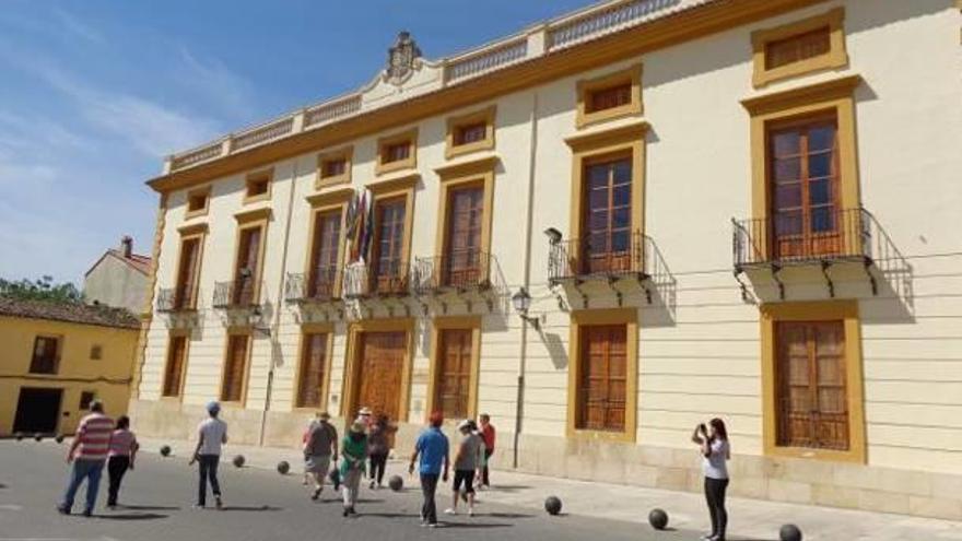 Un grupo de personas pasea por delante del Ayuntamiento de Aielo de Malferit.