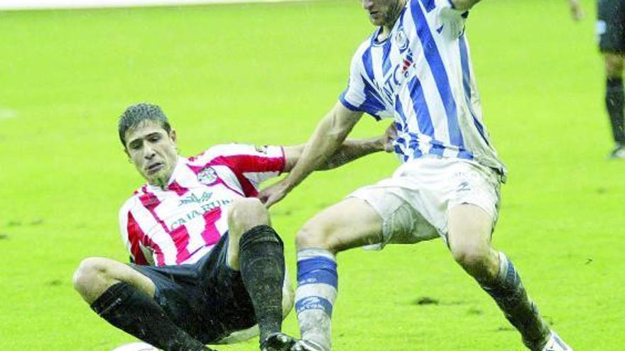 Dani Hedrera, en el suelo, disputa un balón a un jugador de la Real Sociedad B.