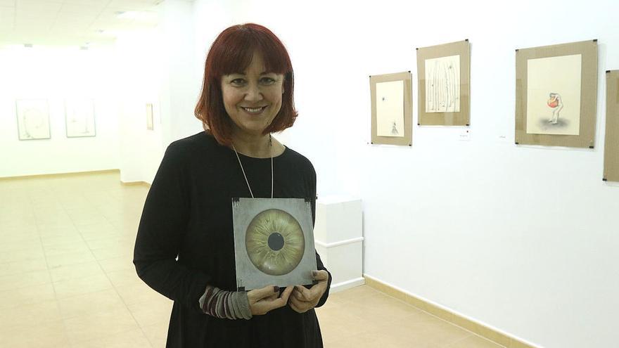 Kora Sánchez, con una de sus obras en mitad de su exposición, el pasado lunes en la sala de Aplama.