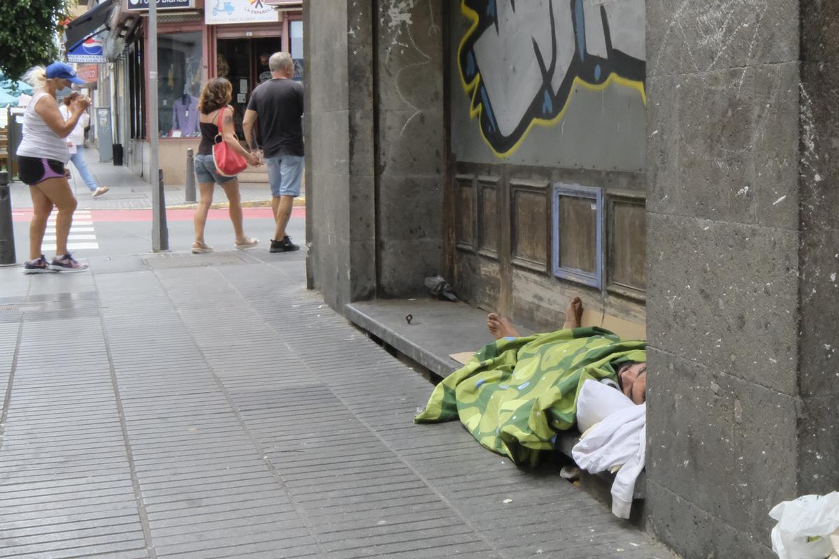 Persona sin techo duerme en una acera de la calle General Vives.