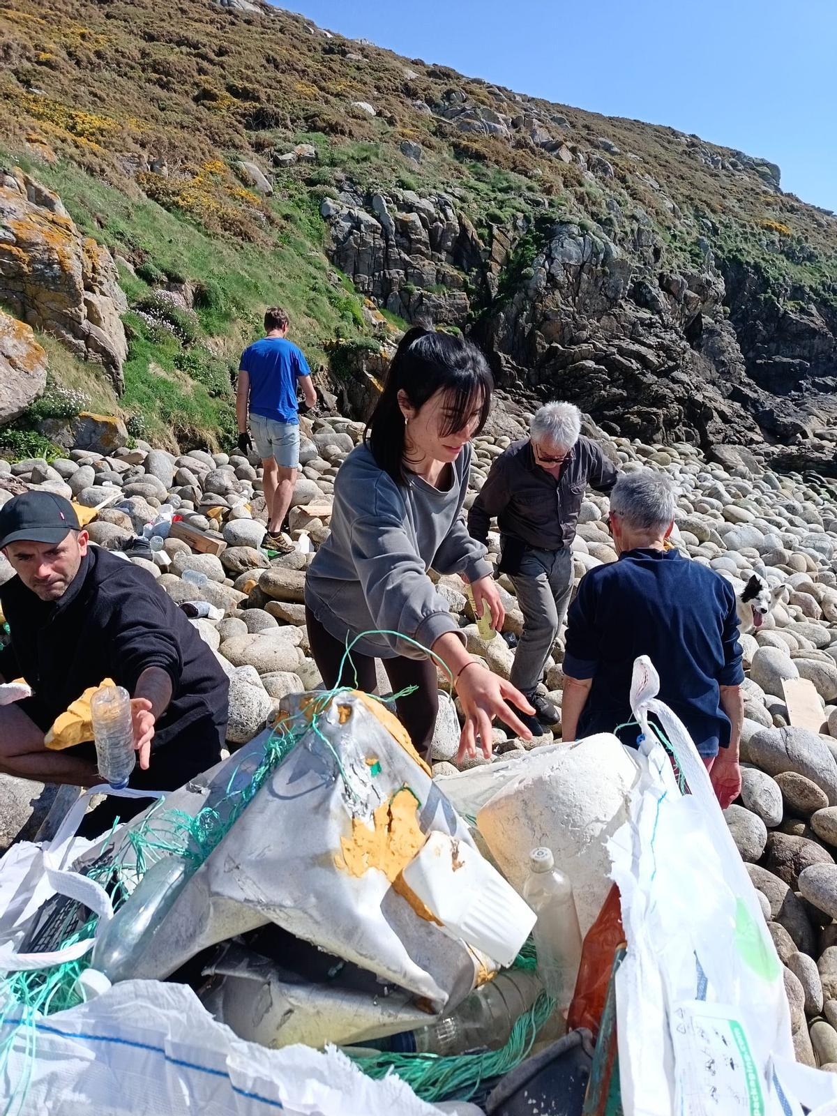 Voluntarios recollendo lixo nos coídos de Touriñán, en Muxía.