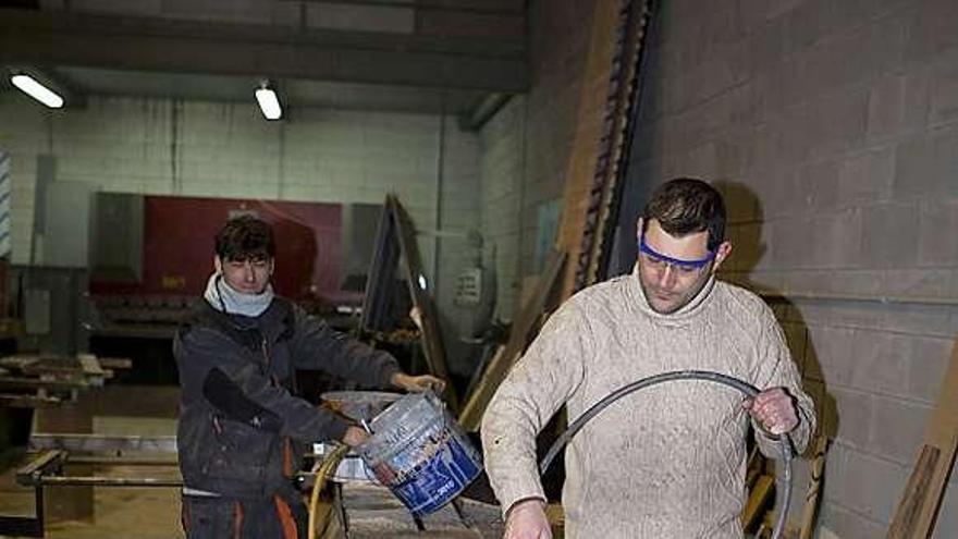 Raimundo García y Juanjo Coble, de Xinergia, trabajan una plancha de metal.
