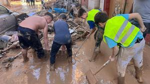 Álvaro, Eric, Hugo y Pablo retiran fango de las calles de Massanassa.