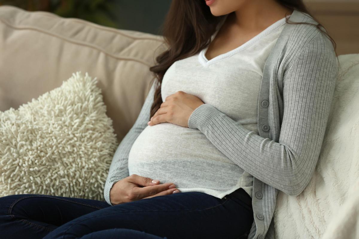 Beautiful pregnant woman resting on sofa at home