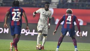 Vinicius Junior, jugador del Real Madrid, encara a Araujo y Koundé, del FC Barcelona, en el clásico de la Supercopa.