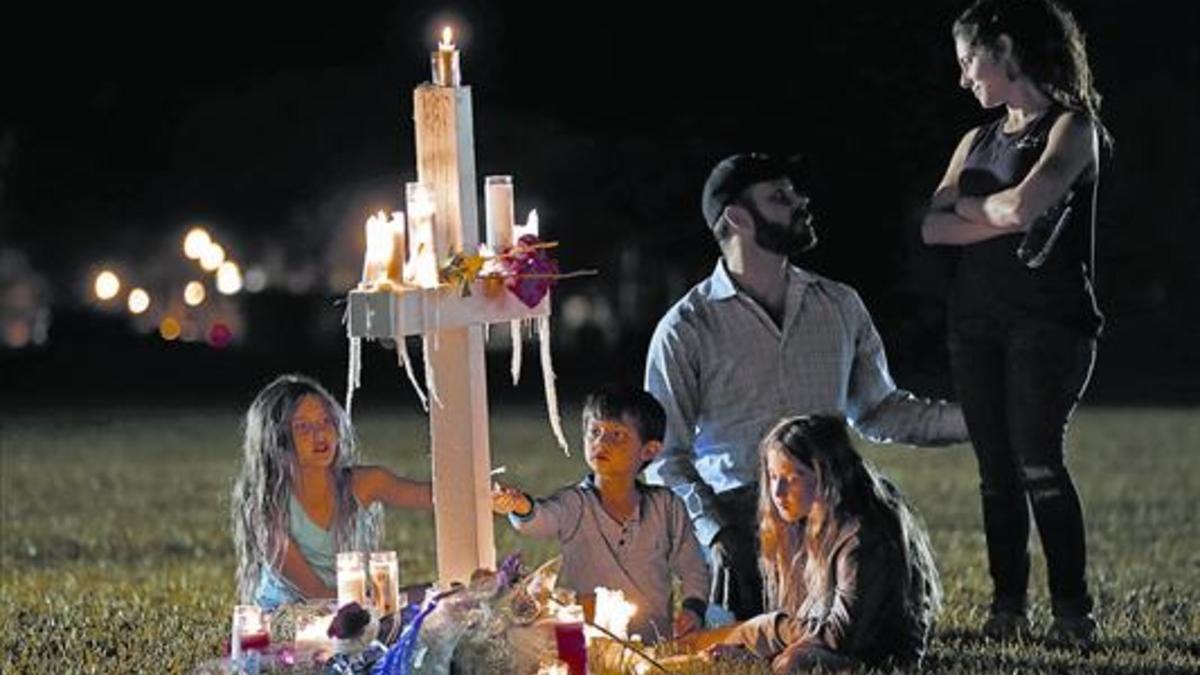 Una familia recuerda a una de las 17 víctimas de la matanza, ante el instituto de Parkland, en Florida.