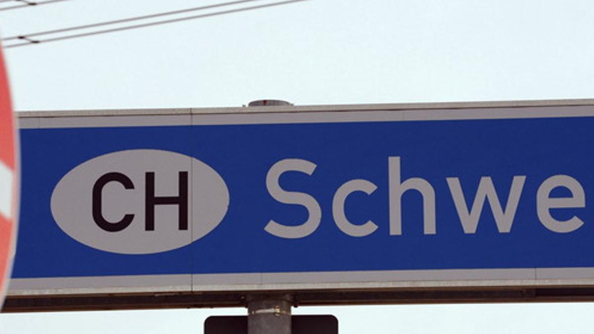 Una señal de prohibido el paso junto a un cartel que señala la entrada en Suiza, en la frontera con Alemania.
