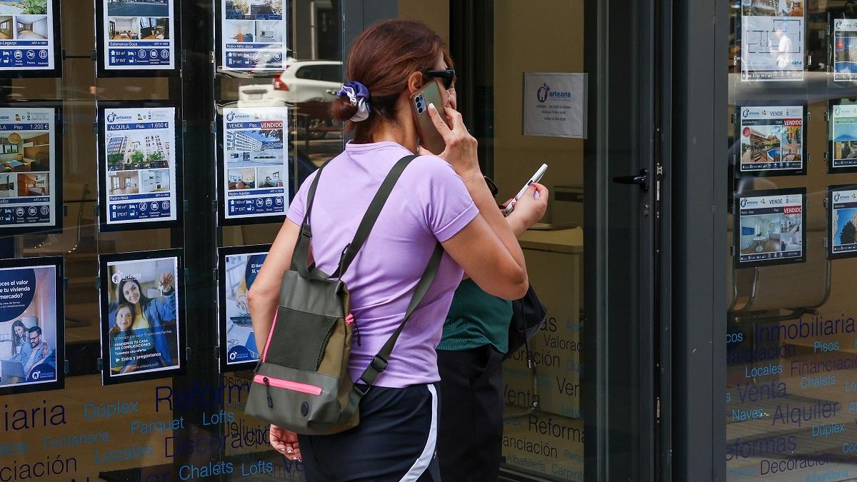 Anuncios de pisos en el escaparate de una inmobiliaria.