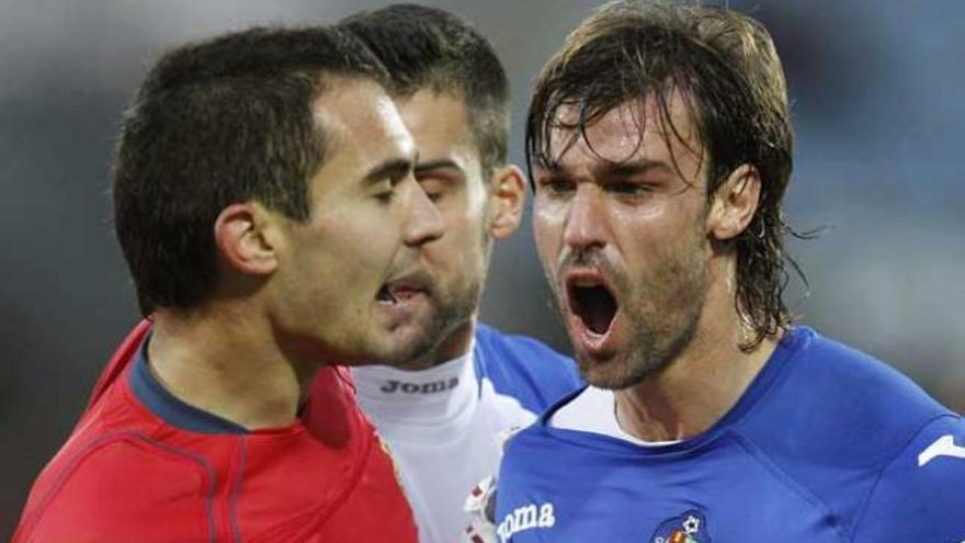 El defensa del Getafe Juan Valera (d) discute con el centrocampista argentino de Osasuna, Emiliano Armenteros en el partido de la decimosexta jornada de liga en Primera División que se disputa esta tarde en el Coliseo Alfonso Pérez.