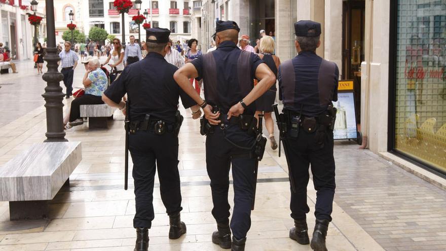 Tres policías nacionales por calle Larios.