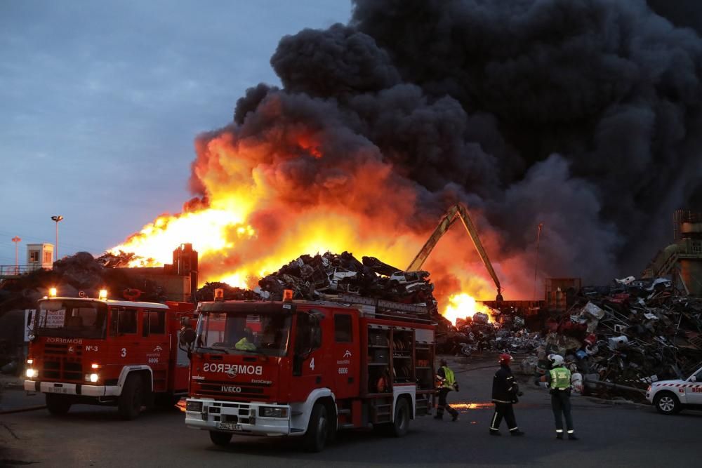 Labores de extinción del incendio de un desguace en Gijón