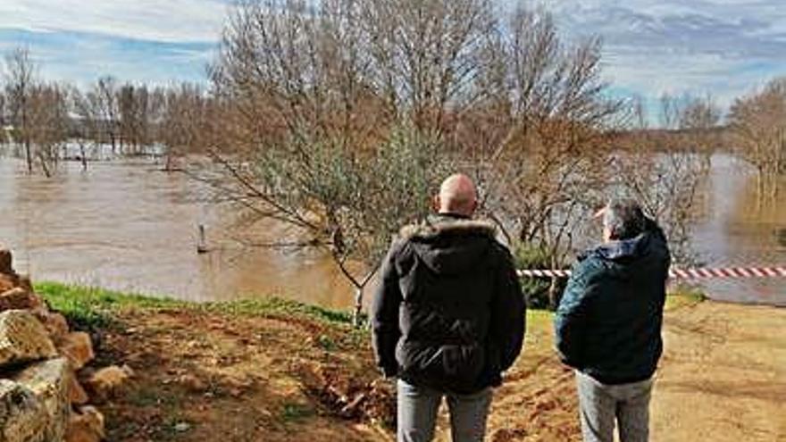 Dos vecinos observan las tierras anegadas por la crecida del Duero registrada en diciembre.